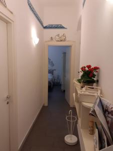 pasillo que conduce a un baño con lavabo y espejo en L'Angelo Blu, en La Spezia