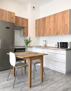 Una cocina con una mesa y sillas de madera. en Apartament Czechowska Luxury, en Lublin