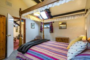 a bedroom with a bed with a wooden bed frame at The Loft - 1 Bedroom Apartment - Saint Florence, Tenby in Saint Florence
