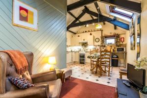 a living room with a couch and a tv and a kitchen at The Loft - 1 Bedroom Apartment - Saint Florence, Tenby in Saint Florence