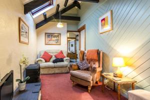 a living room with a couch and a chair at The Loft - 1 Bedroom Apartment - Saint Florence, Tenby in Saint Florence