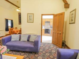 a living room with a purple couch and a table at Wheelhouse Cottage in Whitby