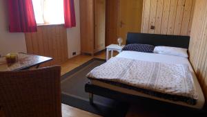 Un dormitorio con una cama y una mesa. en Ferienwohnung Hein, en Chieming