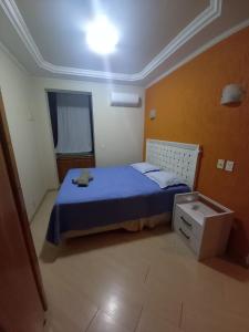 ein kleines Schlafzimmer mit einem blauen Bett und einer Schublade in der Unterkunft Apartamento Assu in Rio de Janeiro