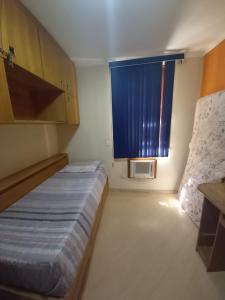 ein kleines Schlafzimmer mit einem Bett und einem Fenster in der Unterkunft Apartamento Assu in Rio de Janeiro