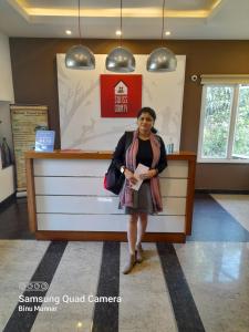 a woman is standing in front of a counter at SWISS COUNTY in Idukki