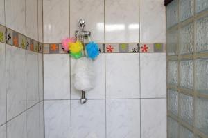 a tiled bathroom with a shower with a bag of yarn at Studio élégant à Baie Mahault de 19 m² avec balcon et parking in Baie-Mahault