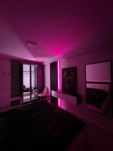 een slaapkamer met paarse verlichting op de muren en een bed bij 090 Area in Tirana
