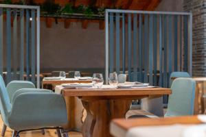 a wooden table with chairs and wine glasses on it at Aparthotel AnyosPark Mountain & Wellness Resort in Anyós