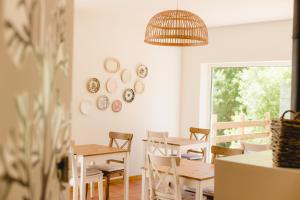 ein Esszimmer mit Tischen, Stühlen und einem Fenster in der Unterkunft Retiro do Bosque Country House in Minde