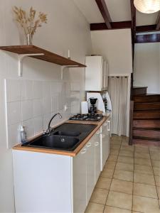 cocina con fregadero y fogones en VIEUX PASSAGE, Maison avec cour privée à 150 m du PORT et de la PLAGE, en Plouhinec