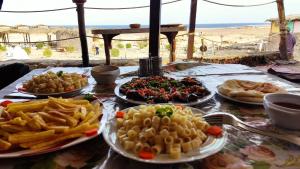 Bedouin Valley Eco Resort في مرسى علم: طاولة مليئة بأطباق الطعام والبطاطا المقلية