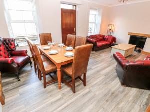 a living room with a wooden table and chairs at Rock House in Haverfordwest
