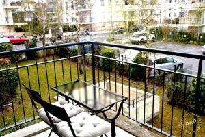 Un balcón con una mesa y sillas y una calle. en Superbe appartement T2 de 50m2 près de Genève à Saint Julien en Genevois idéal pour couple avec 2 enfants jusqu'à 18 ans, en Saint-Julien-en-Genevois