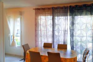a table and chairs in a room with a window at Superbe appartement T2 de 50m2 près de Genève à Saint Julien en Genevois idéal pour couple avec 2 enfants jusqu'à 18 ans in Saint-Julien-en-Genevois