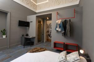 a bedroom with a bed and a desk and a tv at 81 Suite and Breakfast in Catania