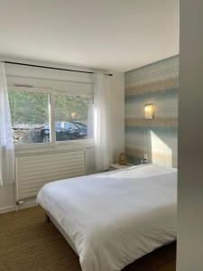 a bedroom with a large white bed and a window at CAMP DE BASE SUR LE LAC DU BOURGET in Le Bourget-du-Lac