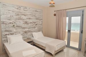 凱法洛斯的住宿－藍海浪公寓，一间卧室设有两张床和一个海景窗户。