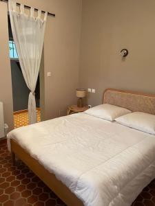 ein Schlafzimmer mit einem weißen Bett mit einem Fenster in der Unterkunft Villa bord de mer in Torreilles