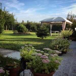 a garden with a gazebo and flowers in pots at I Due Orfici in Cona