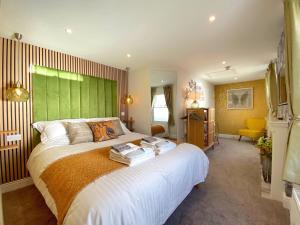 Schlafzimmer mit einem großen Bett mit einem grünen Kopfteil in der Unterkunft Hambrook House Canterbury - NEW luxury guest house with ESPA Spa complex in Canterbury