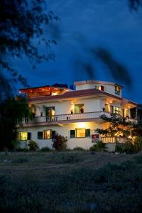 una gran casa blanca por la noche con sus luces encendidas en Casa Strela B&B Tarrafal en Tarrafal