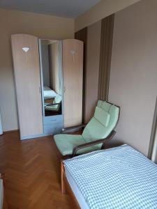 a bedroom with a bed and a chair and a mirror at Ferienwohnung Madlene 1 in Gablitz