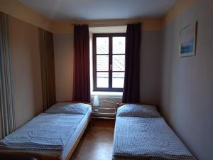 two beds in a room with a window at Ferienwohnung Madlene 1 in Gablitz