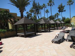 een groep parasols en stoelen op een patio bij Garden Relax Apartments, by Comfortable Luxury in Corralejo