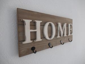 a wooden sign with the word home on a wall at Garden Relax Apartments, by Comfortable Luxury in Corralejo