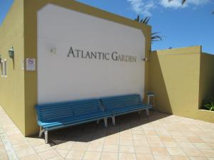 a blue bench sitting in front of a white wall at Garden Relax Apartments, by Comfortable Luxury in Corralejo