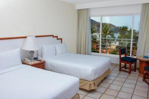 Un pat sau paturi într-o cameră la Emporio Ixtapa - with Optional All Inclusive