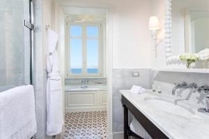 a white bathroom with a sink and a window at Rocco Forte Villa Igiea in Palermo