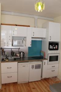 a kitchen with white cabinets and a black counter top at Two Top Central Unique Artisan Beach Studios - also separate spa cabin in Brighton & Hove