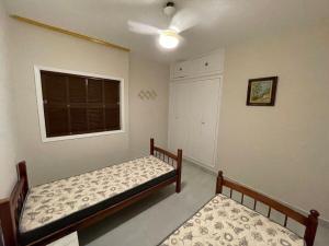 um quarto com 2 camas e uma janela em Apartamento confortável na praça central em Águas de Lindoia