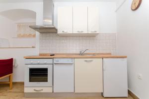 uma cozinha com armários brancos e um lavatório em Apartment Ane em Split