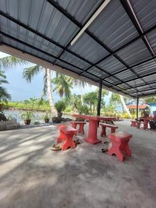 a group of picnic tables under a large roof at Pink Homestay D'Perlis in Kangar