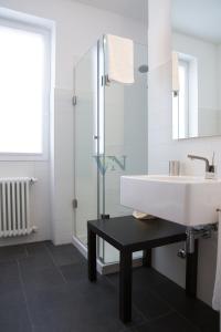 ein Bad mit einem Waschbecken und einer Glasdusche in der Unterkunft Villa Navalia in Menaggio