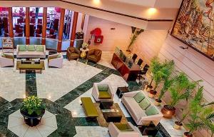 a lobby with couches and plants in a building at Hotel Hindusthan International, Varanasi in Varanasi