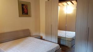 um pequeno quarto com 2 camas e um espelho em Appartamento i Cipressi em Figline Valdarno