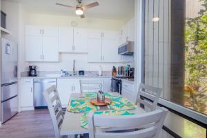 a kitchen with a table and white cabinets and a table and chairs at Waikoloa Villages E108 in Waikoloa Village