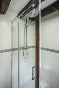 a shower with a glass door in a bathroom at River Cottage, Melverley in Melverley
