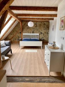 a bedroom with a bed and a stone wall at Farma Klokočov in Vítkov