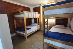 a bedroom with two bunk beds and a brick wall at Bungalow Sol del Sur in Paracas