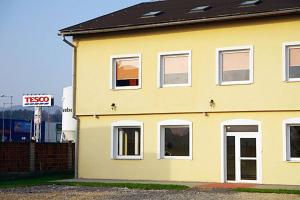 a yellow house with a sign in front of it at Penzión* ADONAI SLOVAKIA in Banská Bystrica