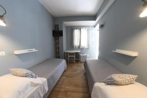 アグローポリにあるMontì B&Bのベッド2台とテーブルが備わる客室です。