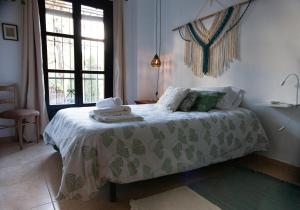 een slaapkamer met een bed met een groene en witte deken bij Casa Guidai in Granada