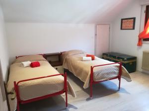 Habitación con 2 camas y una silla. en appartamento Florianca, en Tarvisio