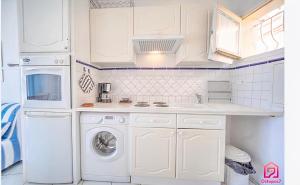 カンヌにあるMaison AnneMarie - Appartamento Lungomareのキッチン(白いキャビネット、洗濯機、乾燥機付)