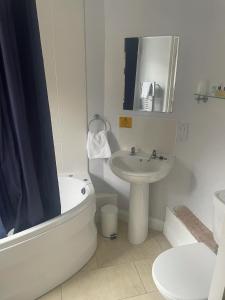 a bathroom with a sink and a tub and a toilet at The Moorings Hotel in Edmondsley